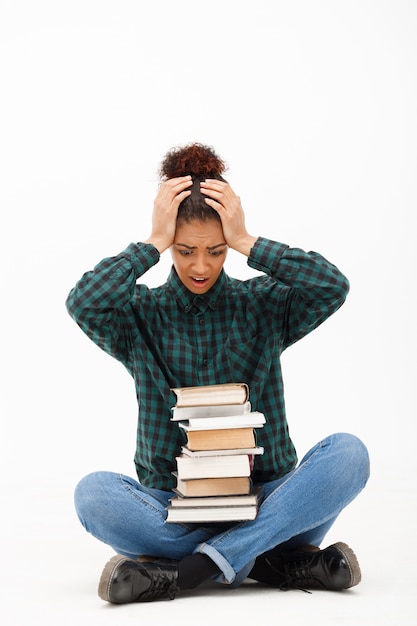 Retrato de joven africana con libros en blanco. | Foto Gratis