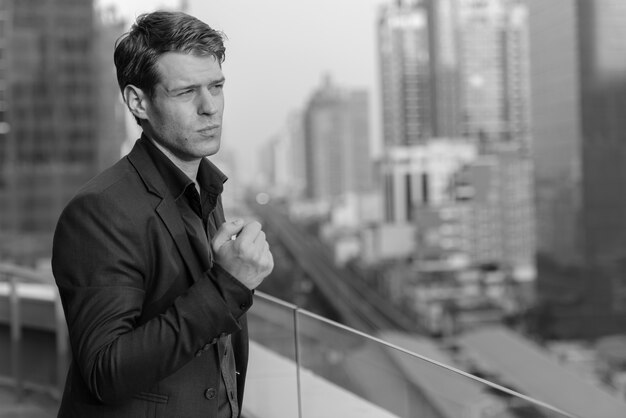 Retrato De Joven Empresario Guapo En Traje Contra La Vista De La Ciudad