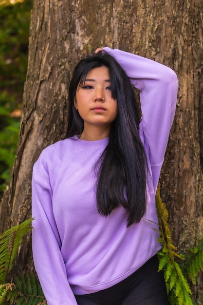 Retrato De Una Joven Morena Asiática En Un Parque Junto A Un árbol Con Un Suéter Rosa Foto 9292