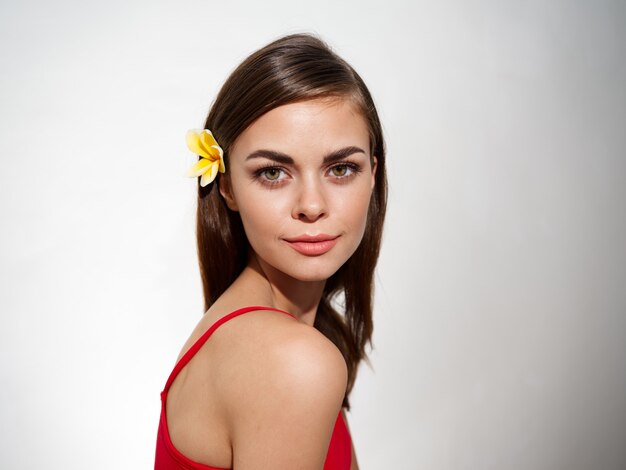 Retrato De Una Mujer Con Una Flor Amarilla En El Pelo Y Una Camiseta