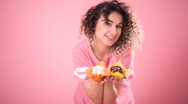 Retrato de una niña alegre con pastelitos en sus manos Foto gratis