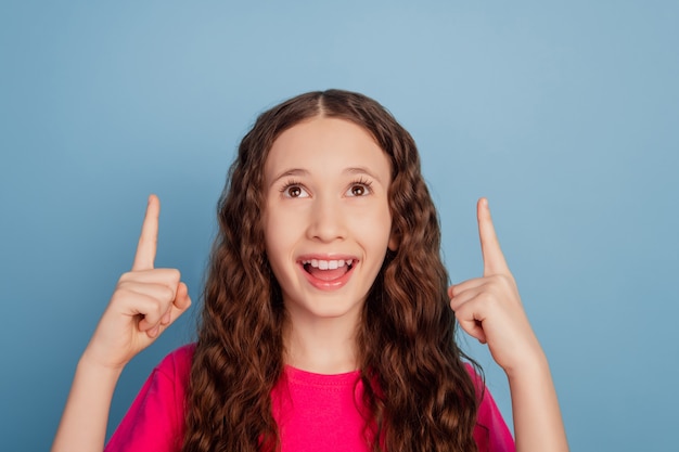 Retrato De Niña Pequeña Curiosa Dedos Directos Espacio Vacío Mirar Hacia Arriba Sobre Fondo Azul 2716