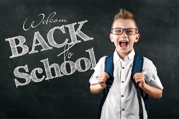 Retrato de un niño de una escuela primaria con el texto regreso a la escuela en una junta escolar Foto Premium