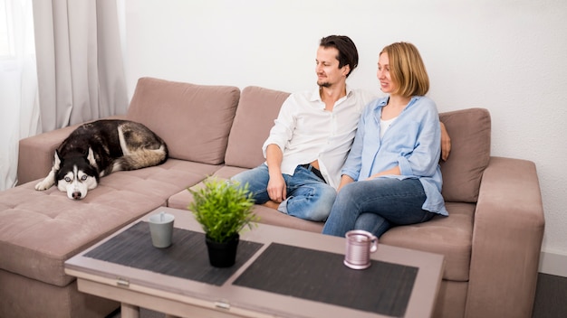 Retrato De Pareja Feliz En Casa Con Perro Foto Gratis