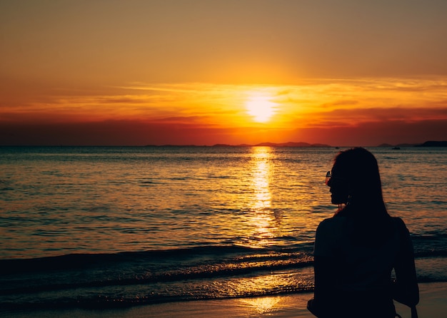 Retrato Trasero De La Vision De Una Mujer Sola Con Las Gafas De Sol En La Puesta Del Sol De La Playa Foto Premium