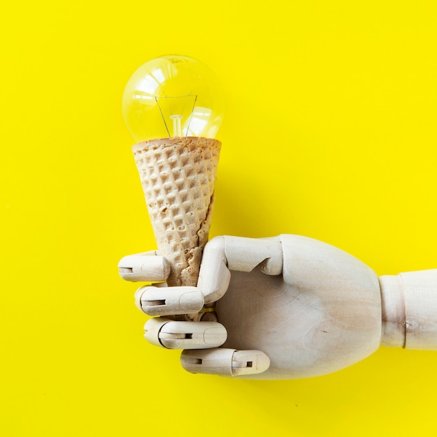 Robot de mano sosteniendo una bombilla de helado. Foto gratis