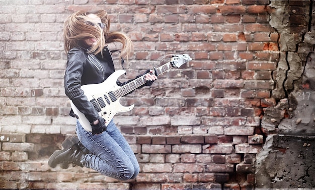 Rockero hermosa joven con guitarra eléctrica canta una chica músico de