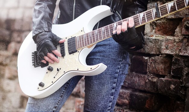 Rockero hermosa joven con guitarra eléctrica canta una chica músico de