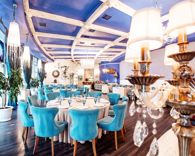 Sala de restaurante con sillas turquesas, techo de color azul marino