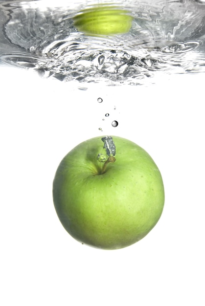 Salpicaduras De Agua Dulce En Manzana Verde Aislado En Blanco Foto