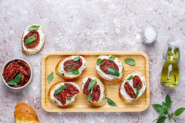 Sándwiches italianos: bruschetta con queso, tomates secos y albahaca