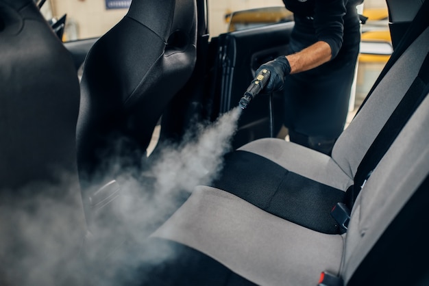 Servicio de lavado de autos, trabajador masculino con guantes limpia