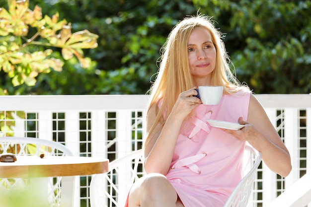 Sexy Mujer De Mediana Edad Vestida Con Un Vestido Rosa Se Sienta Contra