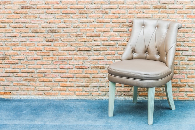 Silla de cuero de lujo sobre fondo de pared de ladrillo Foto gratis