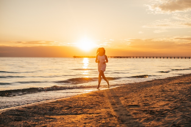 Silueta De Joven Hermosa Mujer Delgada En La Playa Al Atardecer Foto Premium