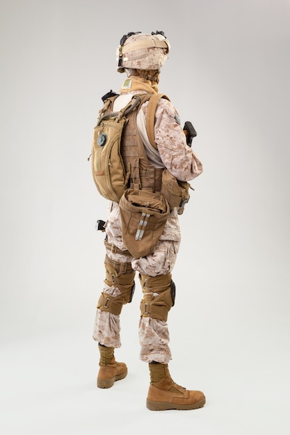 Soldado en uniforme de infantería de marina estadounidense con rifle sobre fondo gris claro, foto de estudio Foto Premium