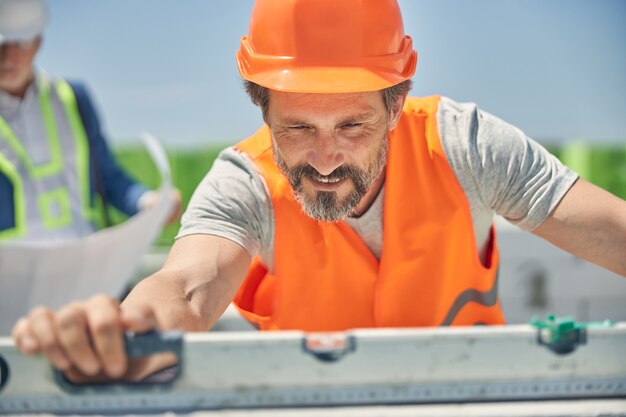 Sonriendo Constructor Maduro Concentrado Colocando Un Nivel De Burbuja