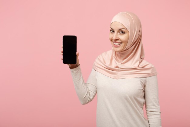 Sonriente joven mujer musulmana árabe en ropa ligera hiyab posando