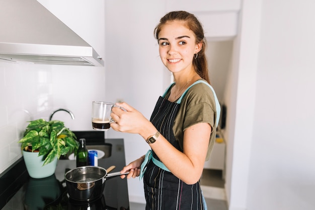 Sonriente Mujer Agua Hirviendo En La Olla Con Taza De Café Foto Gratis 