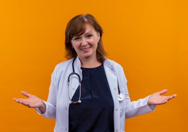 Sonriente mujer de mediana edad médico vistiendo bata médica y