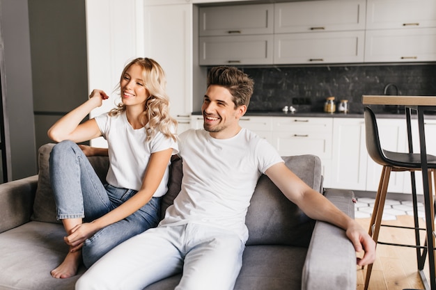 Sonriente Pareja Sentada En Un Sofá En Apartamentos Modernos Y Viendo