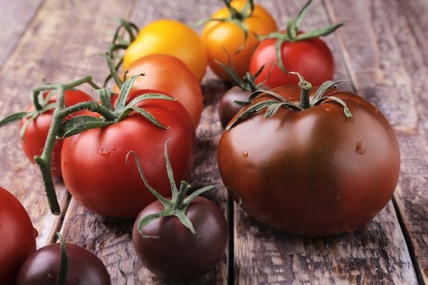 Surtido de tomates coloridos orgánicos frescos en superficie de madera