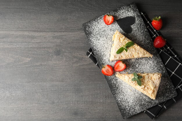 Tablero con trozos de pastel de napoleón con fresa sobre superficie