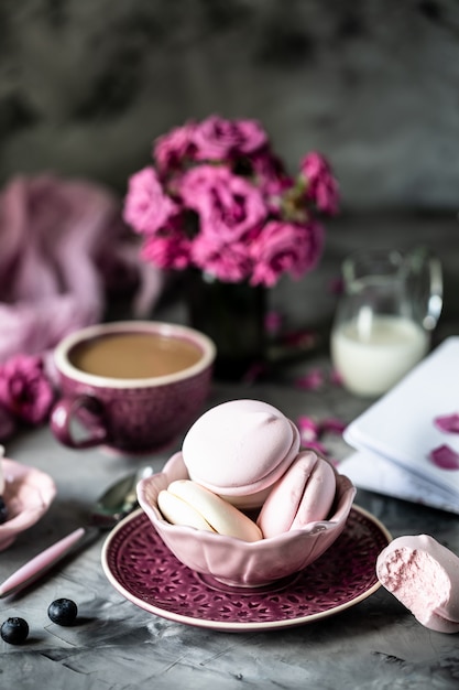 https://image.freepik.com/foto-gratis/taza-cafe-desayuno-malvaviscos-forma-pasteles-macarron-recipiente-negro-sobre-mesa-oscura-flores-vaso_127032-373.jpg