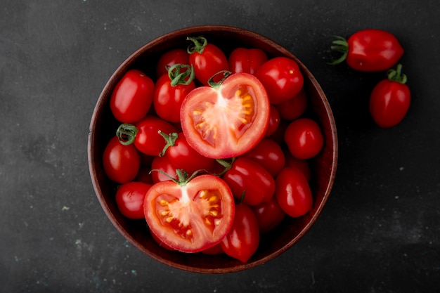 Tazón de tomates en superficie negra Foto gratis