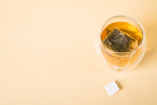 Té verde caliente en taza de vidrio de doble pared con bolsita de té Foto Premium 