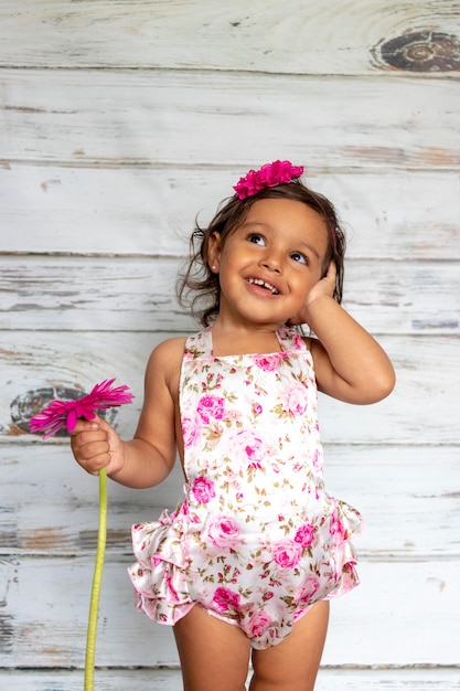 Tierno niño sonriente, con una flor en la mano. | Foto Premium