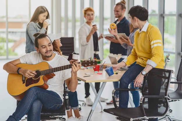 Trabajador Asi Tico Tocando La Guitarra Sobre El Grupo De Empresarios