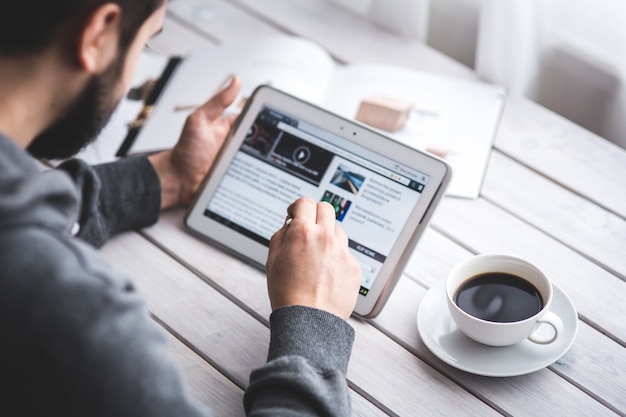Trabajador leyendo noticias con la tableta Foto Gratis Trabajador leyendo noticias con la tableta Foto Gratis