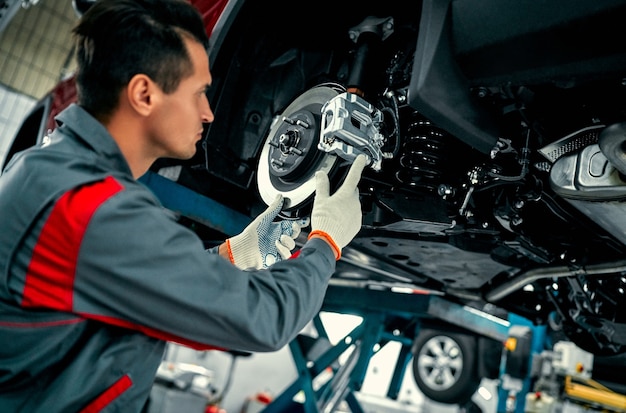 Trabajador Mecánico De Automóviles Que Repara La Suspensión Del ...