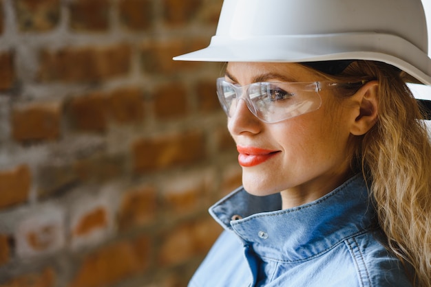 Trabajadora de almacén constructor de mujer en casco ingeniero o