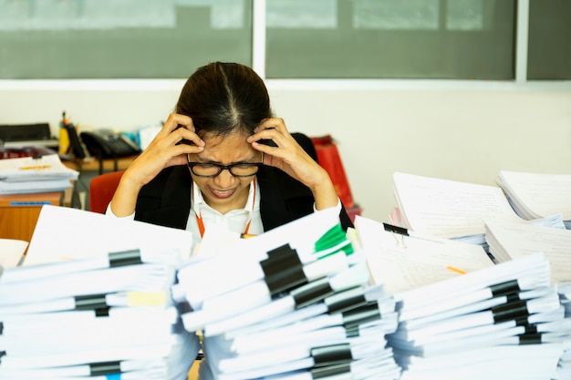La trabajadora de oficina estÃ¡ angustiada con mucho papeleo en su escritorio. Foto Premium 