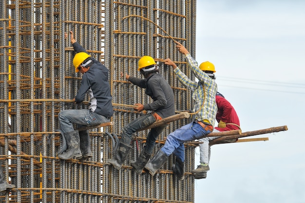 Trabajadores de la construcción atando acero | Foto Premium