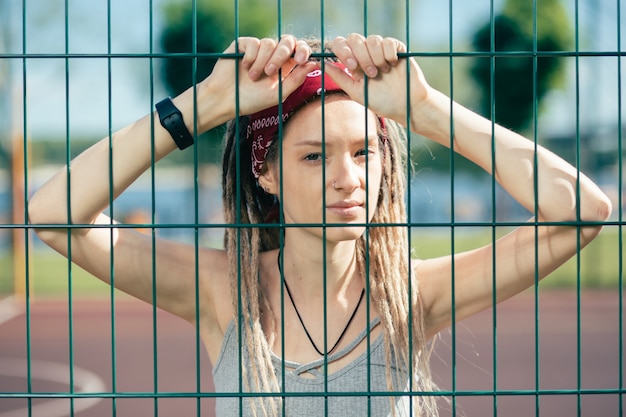 Tranquila señorita pensativa con rastas sonriendo levemente y mirándote