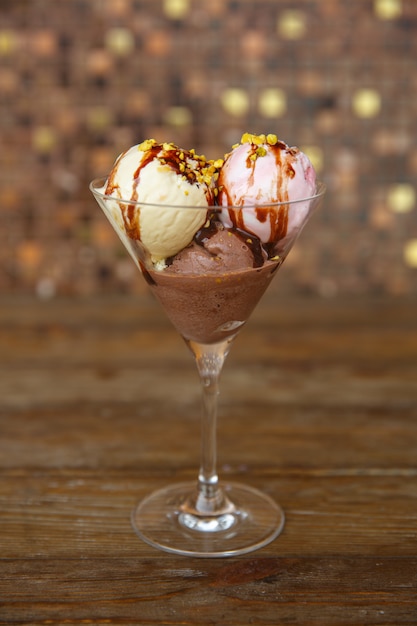 Tres bolas de helado con fresa, vainilla y café cubierto