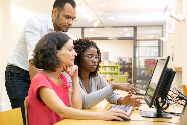 Tutor ayudando a estudiantes en clase de computación Foto gratis