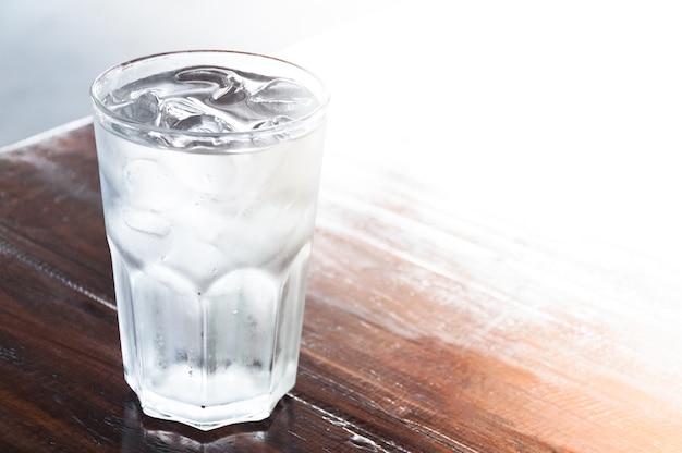 Vaso de agua con hielo en la mesa de madera | Foto Premium