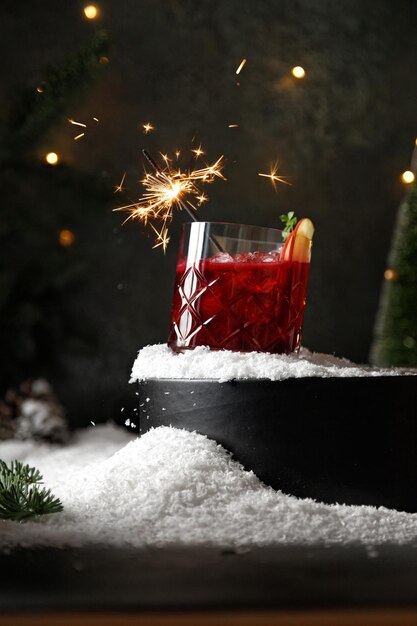 Vaso de ponche rojo o cóctel rojo con hielo en la levitación de la