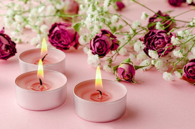 Velas aromáticas encendidas y rosas secas en rosa. concepto de aromaterapia  y romance. | Foto Premium