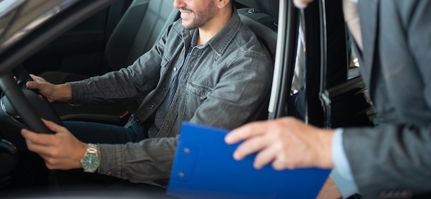 Vendedor Hablando Con Un Hombre Que Está Eligiendo Su Nuevo Coche En Una Sala De Exposición 