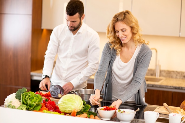 Ver Al Joven Ayudando A Su Novia A Cocinar En La Cocina Moderna Foto Premium