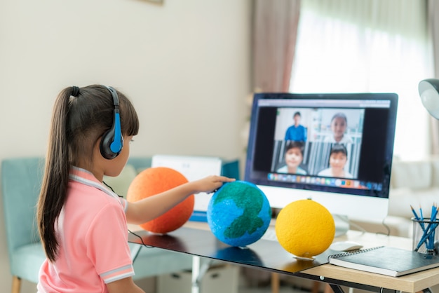 Videoconferencia de aprendizaje en vivo de una estudiante asiática con el maestro y otros compañeros de clase Foto Premium 