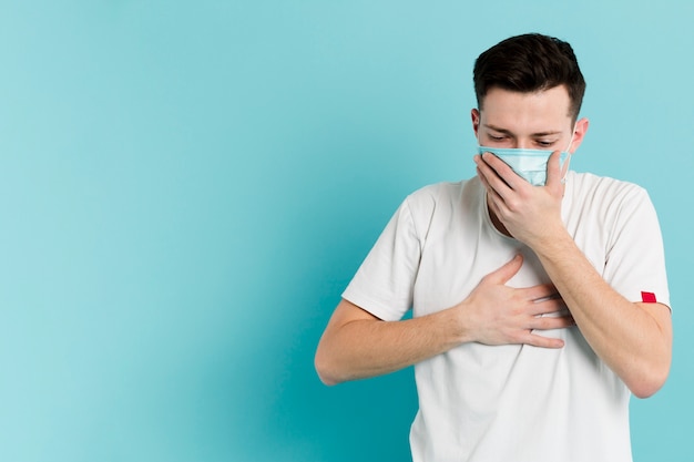 Vista frontal del hombre enfermo tosiendo con una máscara médica | Foto  Gratis