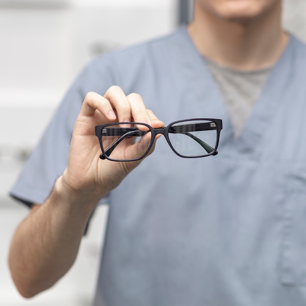 Vista frontal de un par de gafas sostenidas por un hombre ...