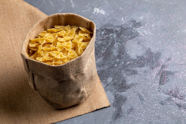 Una Vista Frontal De La Pasta Italiana Cruda Poco Formada Dentro De La Bolsa En La Mesa Gris Comida Italiana Foto Gratis