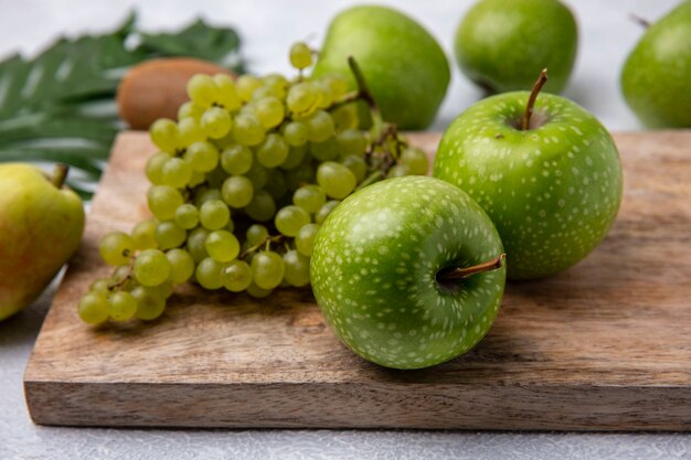 Vista Lateral De Manzanas Verdes Con Uvas Verdes En Un Soporte Sobre Un